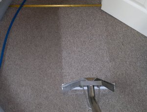 Extraction cleaning the carpet with a floor wand to remove the cleaning products and residual soiling