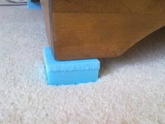 Styrofoam block under the furniture leg to prevent it touching the carpet during drying